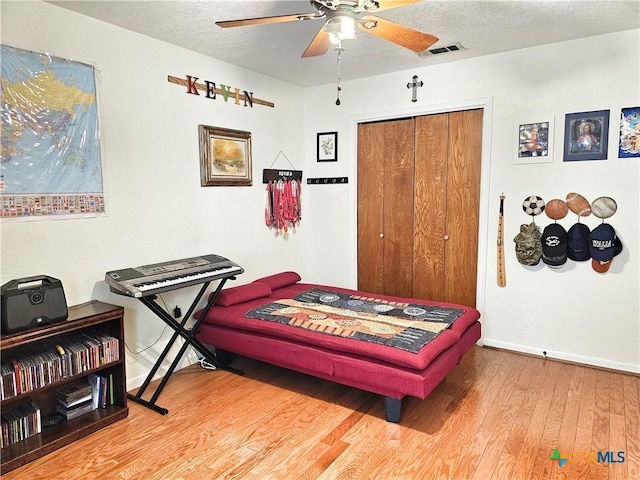 bedroom featuring ceiling fan, a closet, a textured ceiling, and hardwood / wood-style flooring