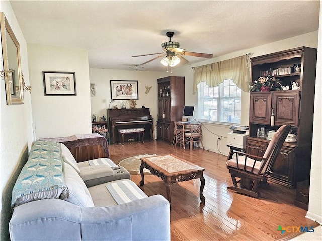 living room with ceiling fan and wood-type flooring