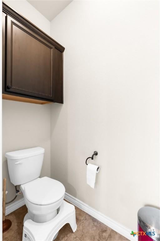bathroom with toilet and baseboards
