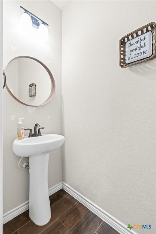 bathroom featuring baseboards and wood finished floors