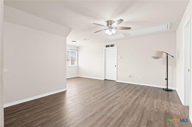 spare room with baseboards, attic access, ceiling fan, and wood finished floors