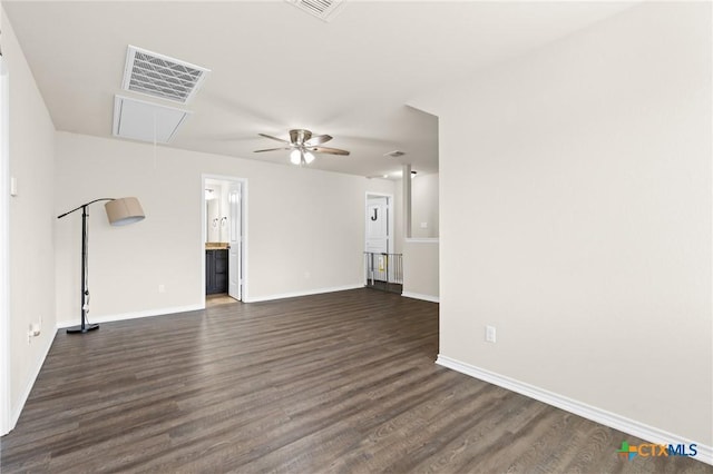 unfurnished living room featuring ceiling fan, attic access, dark wood-style flooring, visible vents, and baseboards