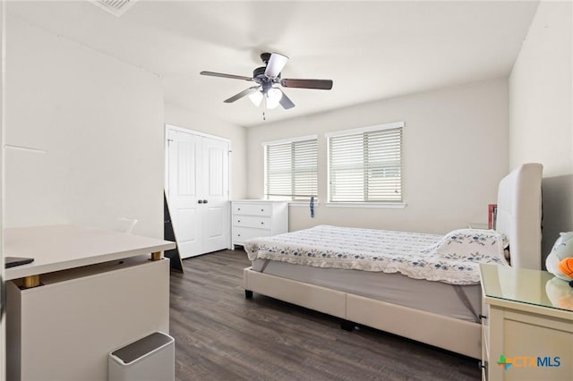 bedroom with a closet, a ceiling fan, visible vents, and dark wood-type flooring