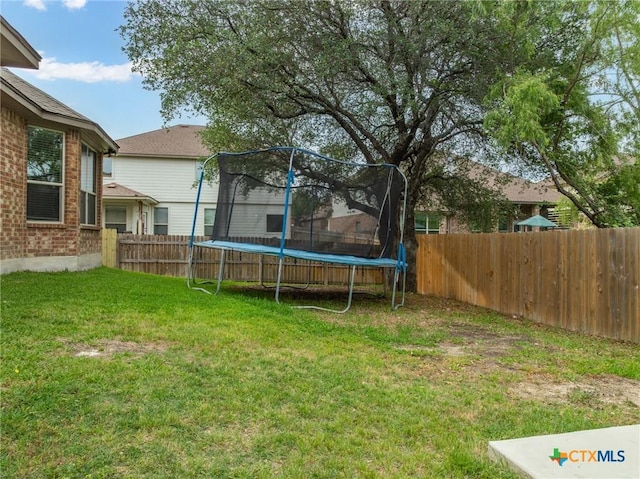 view of yard with a fenced backyard and a trampoline