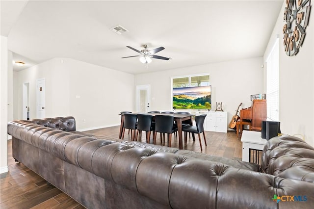 living room with visible vents, dark wood finished floors, ceiling fan, and baseboards