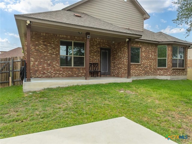 back of property with a patio, fence, and brick siding