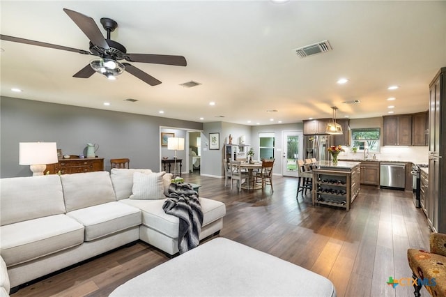 living area with recessed lighting, visible vents, and dark wood finished floors