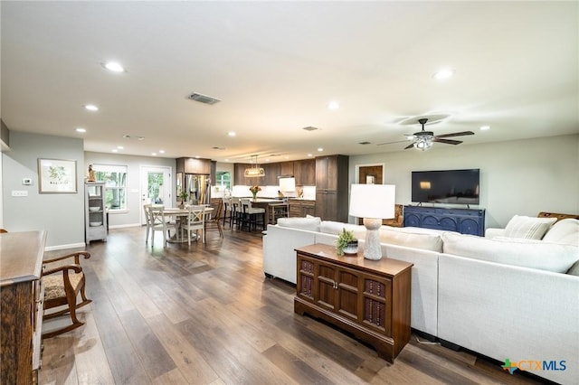 living room featuring dark wood-style flooring, recessed lighting, ceiling fan, and visible vents