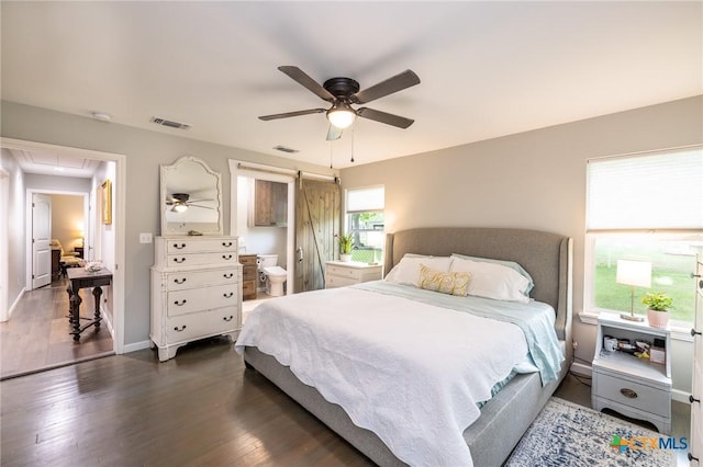 bedroom featuring a ceiling fan, attic access, wood finished floors, and visible vents