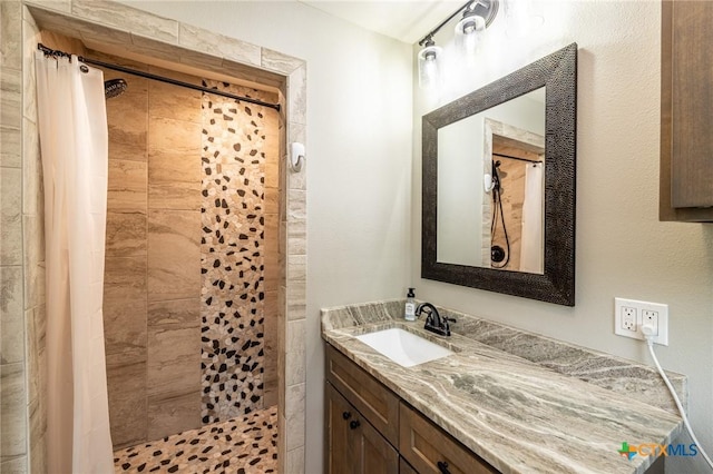 full bath with vanity and a tile shower
