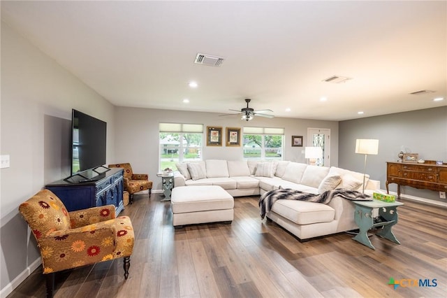 living area featuring recessed lighting, visible vents, and wood finished floors