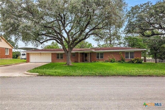 406 Wagner Way, Victoria, TX 77904 - ranch-style home featuring a garage, concrete driveway, a front lawn, and brick siding