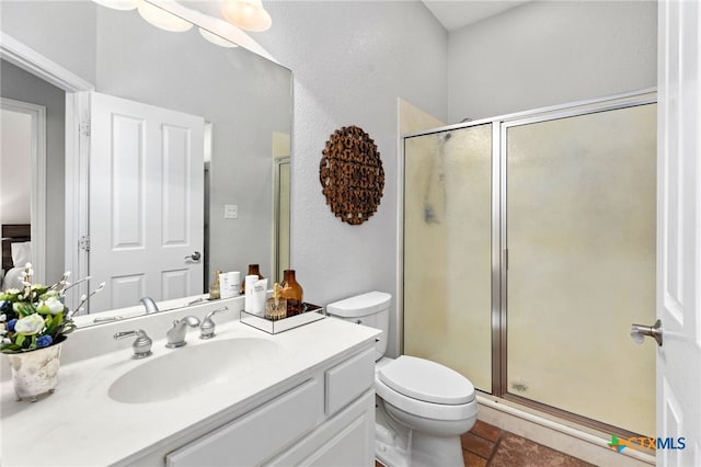 bathroom with a stall shower, toilet, and vanity