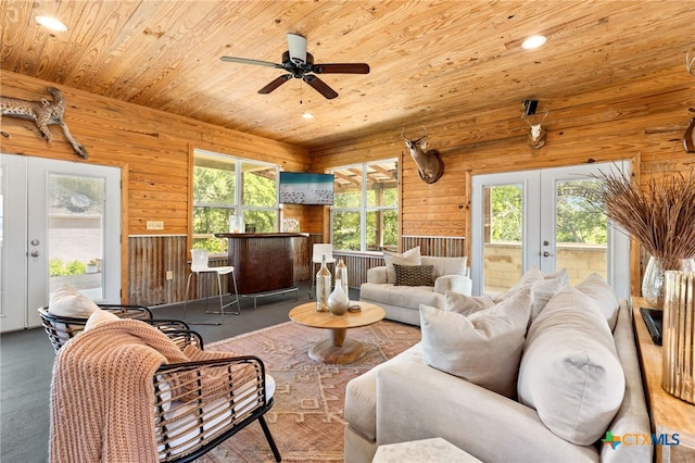 living room with wooden walls, wooden ceiling, and french doors