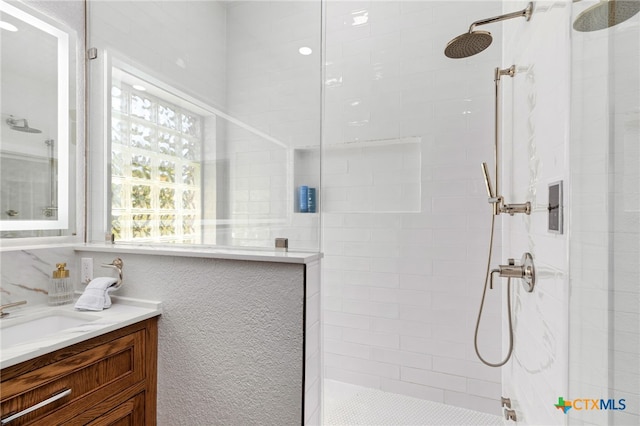 full bath featuring a walk in shower and vanity