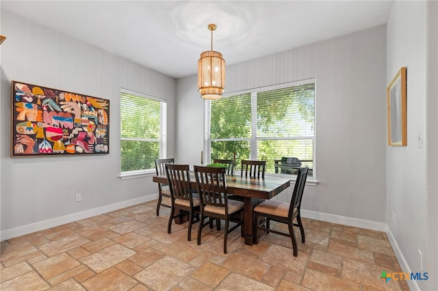 dining room with stone tile floors and baseboards