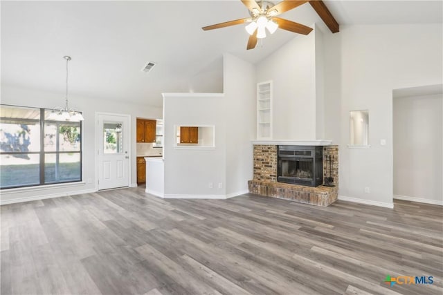 unfurnished living room with hardwood / wood-style floors, high vaulted ceiling, a brick fireplace, ceiling fan, and beamed ceiling