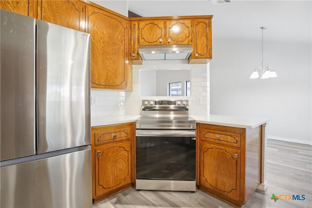 kitchen featuring pendant lighting, light wood-type flooring, tasteful backsplash, kitchen peninsula, and stainless steel appliances