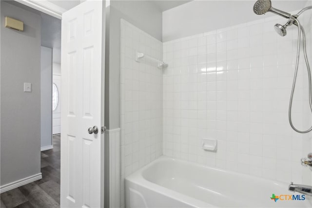 bathroom with wood-type flooring and tiled shower / bath