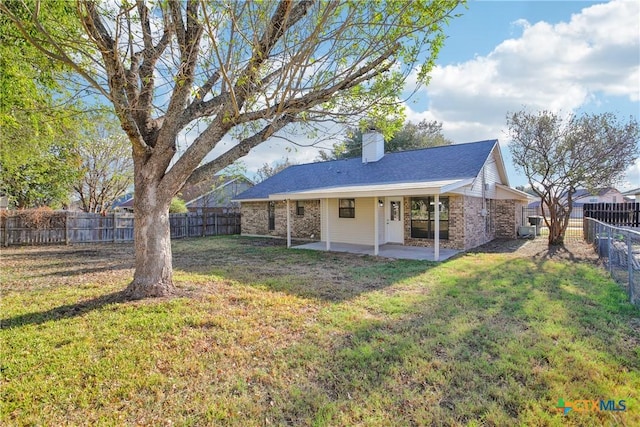 rear view of house with a yard and a patio area