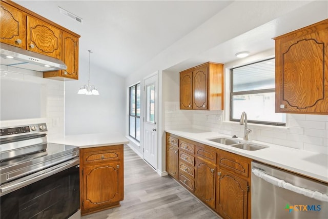 kitchen featuring hanging light fixtures, stainless steel appliances, plenty of natural light, and sink