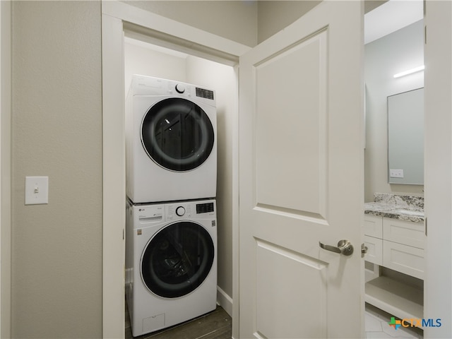 washroom with dark hardwood / wood-style flooring and stacked washer / drying machine