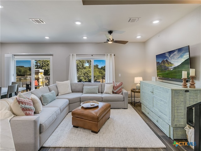 living room featuring hardwood / wood-style floors, ceiling fan, and a fireplace