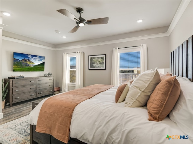 bedroom featuring multiple windows, wood-type flooring, and ceiling fan