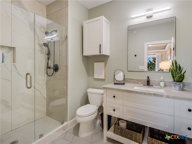 bathroom with vanity, a shower with shower door, tile patterned floors, and toilet