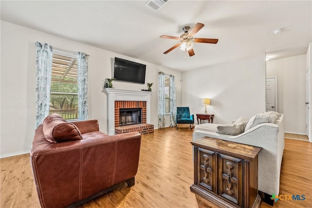 3610 Parkmill Dr, Killeen, TX 76542 - living area featuring a ceiling fan, light wood-type flooring, a brick fireplace, and baseboards