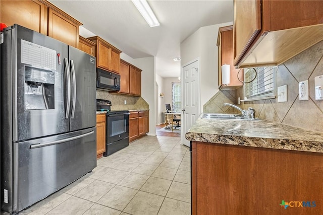 3610 Parkmill Dr, Killeen, TX 76542 - kitchen with black appliances, a sink, light tile patterned floors, brown cabinetry, and backsplash