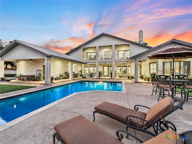 pool at dusk with a patio