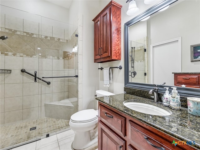 bathroom with toilet, vanity, tile patterned floors, and a shower with shower door