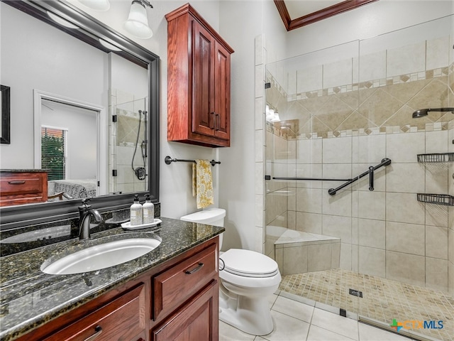 bathroom with toilet, tile patterned flooring, ornamental molding, vanity, and walk in shower