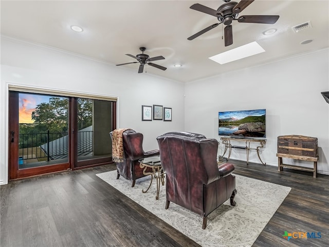 living room with dark hardwood / wood-style flooring, a skylight, ceiling fan, and crown molding