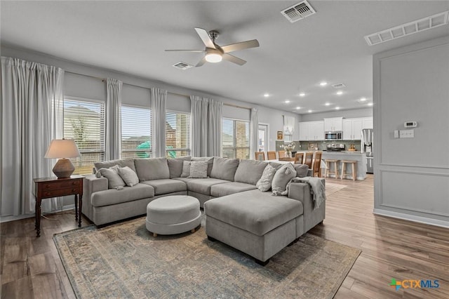 living area featuring visible vents and a healthy amount of sunlight