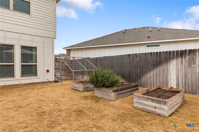 view of yard with fence and a garden