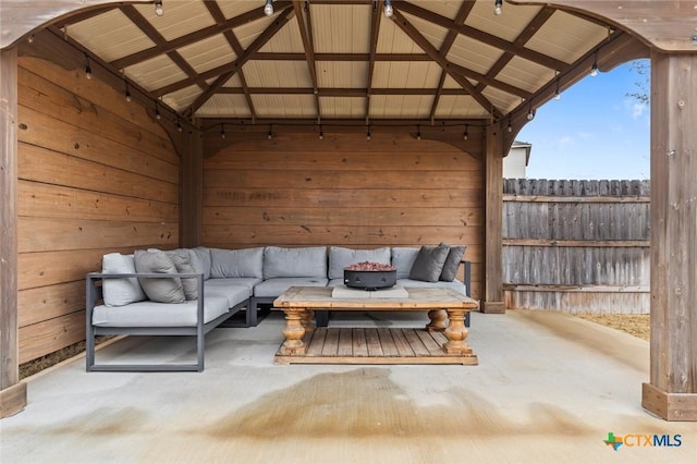 view of patio with a gazebo, an outdoor living space with a fire pit, and fence