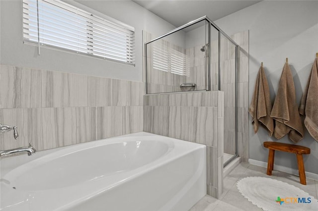 bathroom with a garden tub, a stall shower, and tile patterned floors