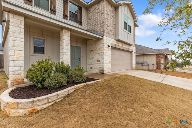 view of front of property featuring stone siding, concrete driveway, and a garage