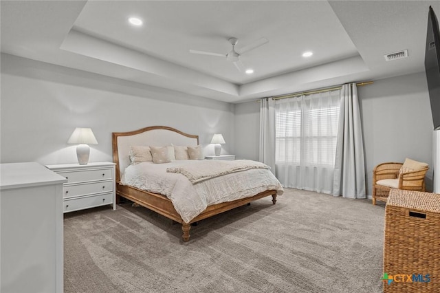 carpeted bedroom with visible vents, recessed lighting, a raised ceiling, and ceiling fan