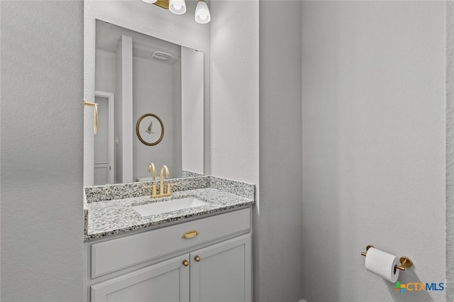 bathroom with vanity and a textured wall
