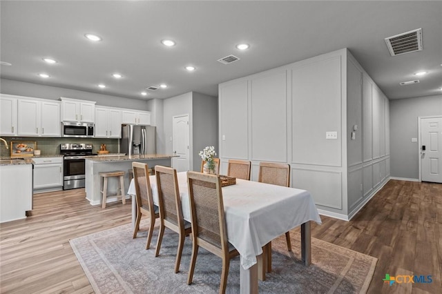 dining room with recessed lighting, visible vents, and light wood finished floors