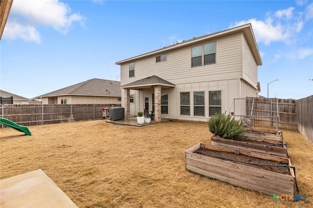 back of house featuring a patio area, a garden, and a fenced backyard