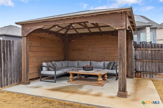 view of patio with an outdoor living space, a gazebo, and fence