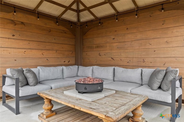 living room featuring lofted ceiling and wooden walls