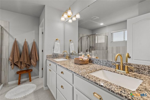 bathroom with a sink, double vanity, a stall shower, and tile patterned floors