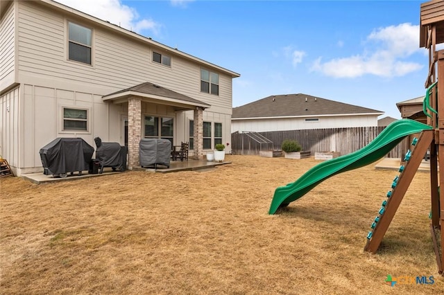 back of property with a playground, a patio area, and a fenced backyard