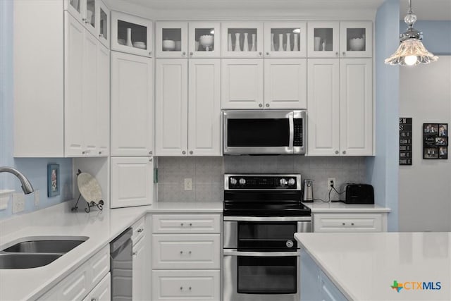 kitchen featuring appliances with stainless steel finishes, white cabinetry, and sink