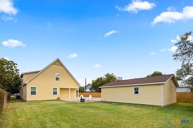 back of house featuring a lawn and a patio area